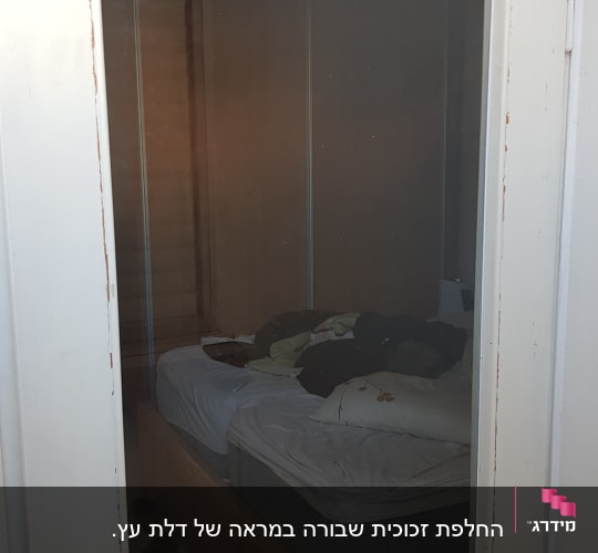דלת זכוכית עם ידית מתכת בחדר שינה